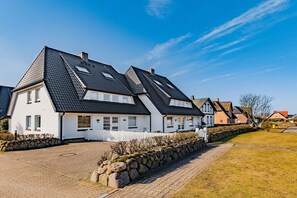 A row of white houses with dark roofs, stone walls, and a paved driveway. - Holiday apartment with 2 bedrooms (Wenningstedt)