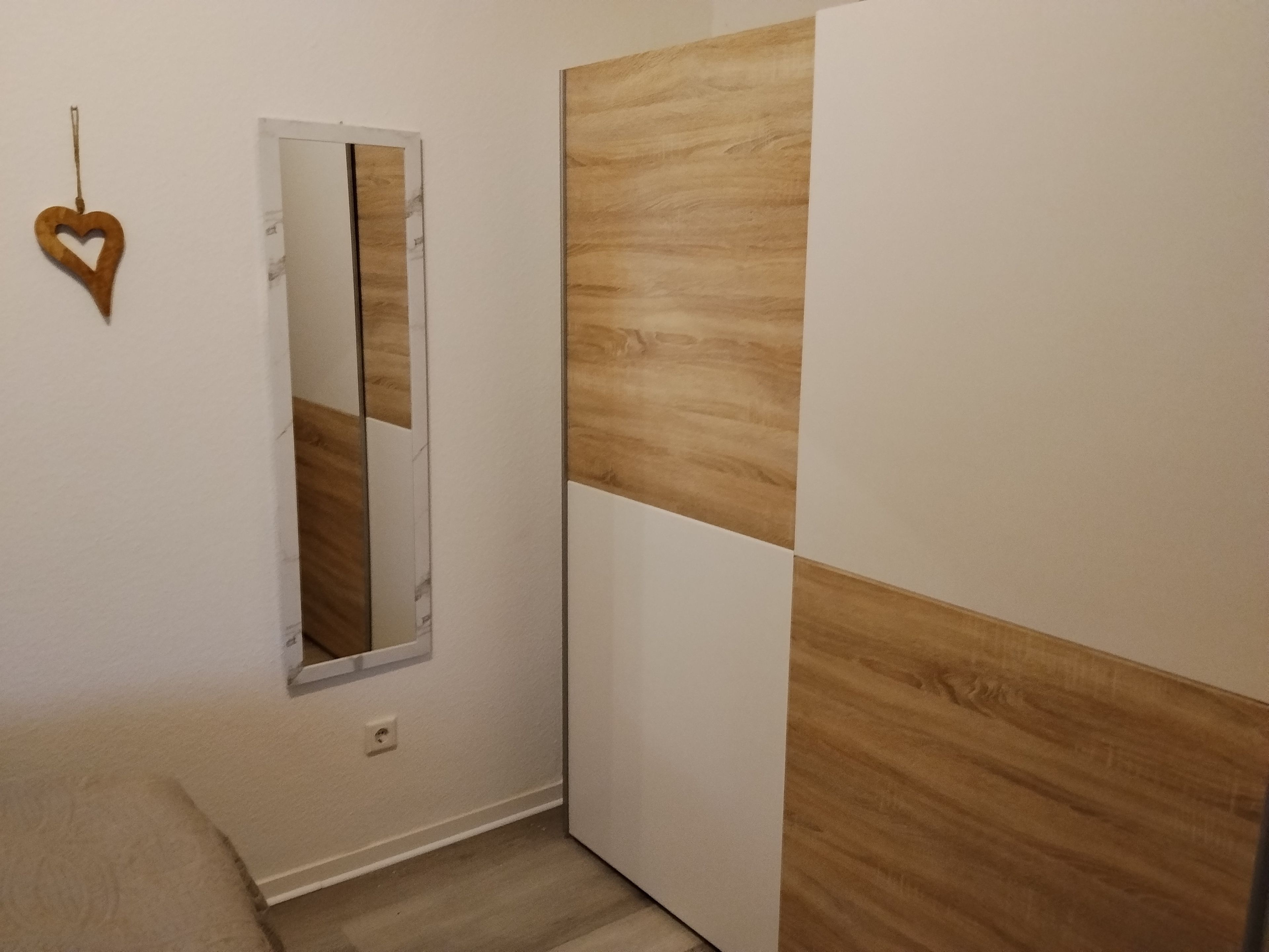 Ein Flur mit Spiegel, Holzpaneelen an der Wand und Teppichboden.