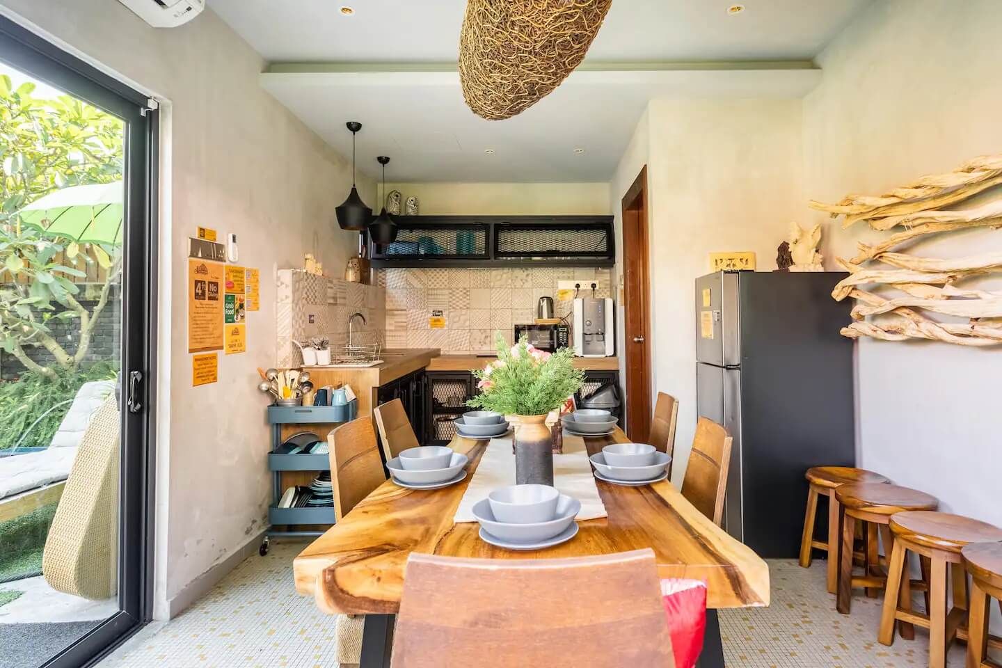 Una cocina moderna con comedor, que incluye una mesa de madera, sillas y una lámpara colgante.