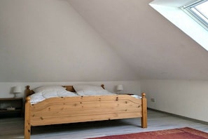 A single bed in a room with a sloped ceiling and a window. - Holiday home with 3 bedrooms (Wangerland-Hooksiel)