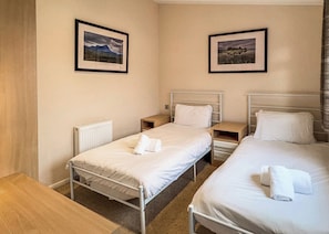 A hotel room with two single beds, a bedside table, a nightstand, and a radiator. - 2 bedroom accommodation in Invermoriston (Invermoriston)
