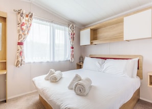 A hotel room with a bed, two nightstands, a window with curtains, and a wooden headboard. - 1 bedroom accommodation in Fort Augustus (Fort Augustus)