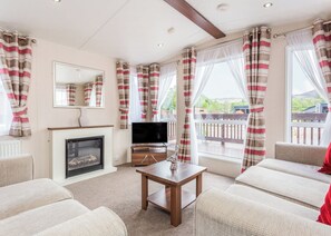 A living room with a fireplace, television, and seating area. - The Ness, Woodland Retreat (Fort Augustus)
