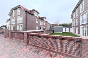 A multi-story brick building with a flat roof and white-framed windows. - Holiday apartment Inselherz (Wangerooge)