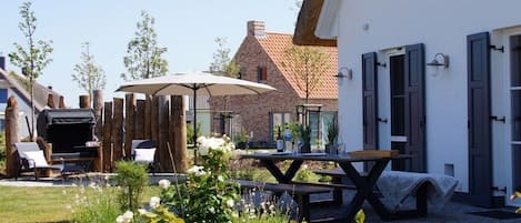 A courtyard with a picnic table, outdoor seating, and a barbecue grill.