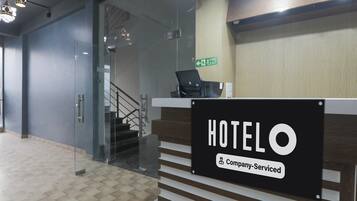 A hotel reception desk with a sign indicating it's company-serviced.