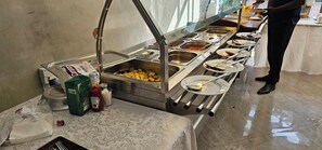 Montaje de bufé con varias estaciones de comida y salsas.