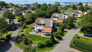 A residential area with houses, a driveway, and a body of water in the background. - Strand Ferien Wohnung Makkum (Makkum)