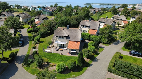 A residential area with houses, a driveway, and a body of water in the background. - Strand Ferien Wohnung Makkum (Makkum)