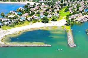 A coastal residential area with houses, a beach, and a large body of water. - Strand Ferien Wohnung Makkum (Makkum)
