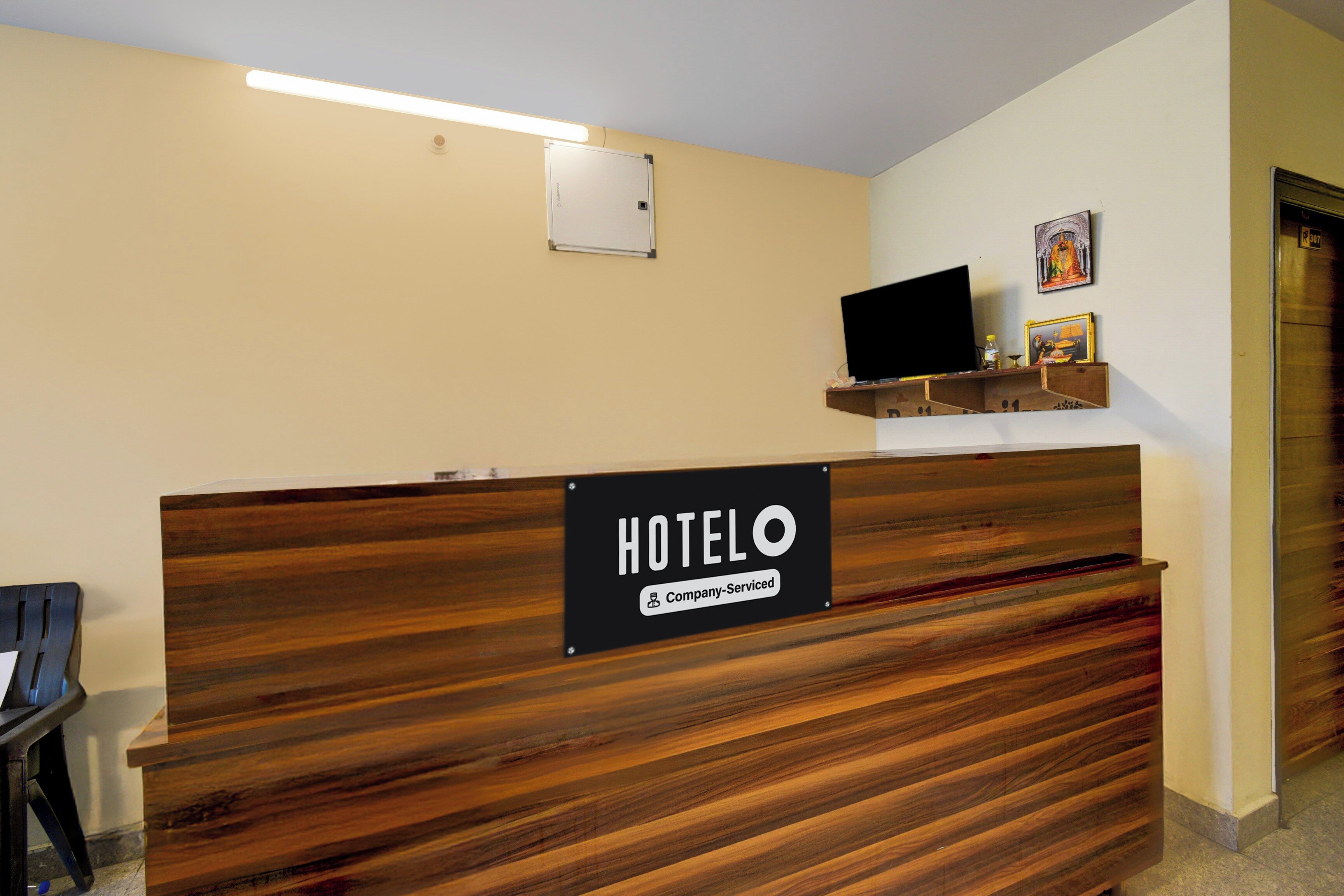 Un mostrador de recepción de hotel con un cartel que indica que el servicio es proporcionado por la empresa.