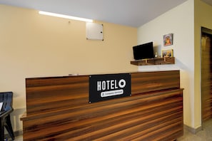 A hotel reception desk with a sign indicating it is company-serviced. - Super Hotel O AMR Planet Mall Hyderabad (Hyderabad)