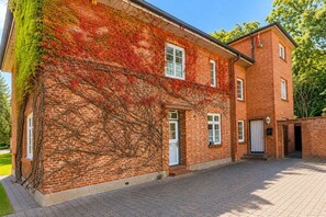 Ein Backsteinhaus mit überdachter Eingangspartei und befestigter Auffahrt.