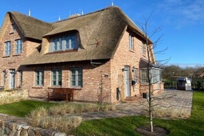 A brick house with a thatched roof and a stone pathway leading to the entrance. - Holiday home in Nieblum with swimming pool (Nieblum)