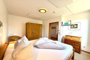 Une chambre à coucher avec un lit, une armoire en bois et une commode.