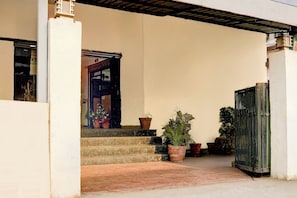 A building entrance with a set of steps leading to a door, surrounded by potted plants. - Super Hotel O Pachgaon Near Kolhapur (Kolhapur)