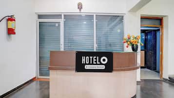 Un comptoir de réception d’hôtel avec une pancarte indiquant qu’il est géré par l’entreprise.