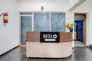 A hotel reception desk with a sign indicating it is company-serviced. - Super Hotel O Pachgaon Near Kolhapur (Kolhapur)
