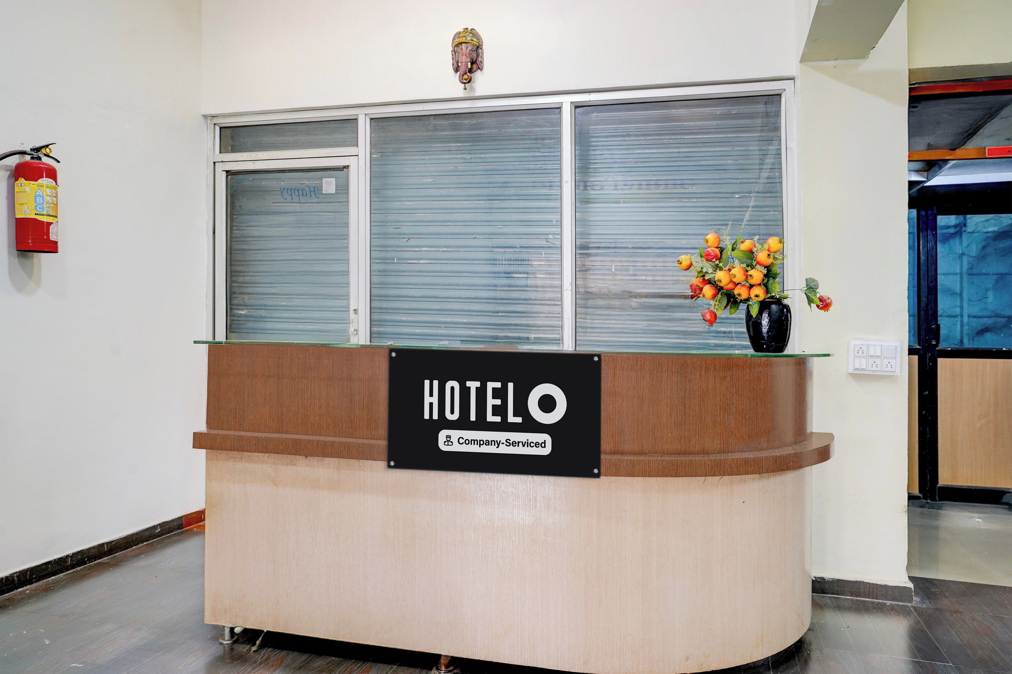 A hotel reception desk with a sign indicating it is company-serviced.