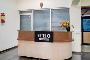 A hotel reception desk with a sign indicating it is company-serviced.
