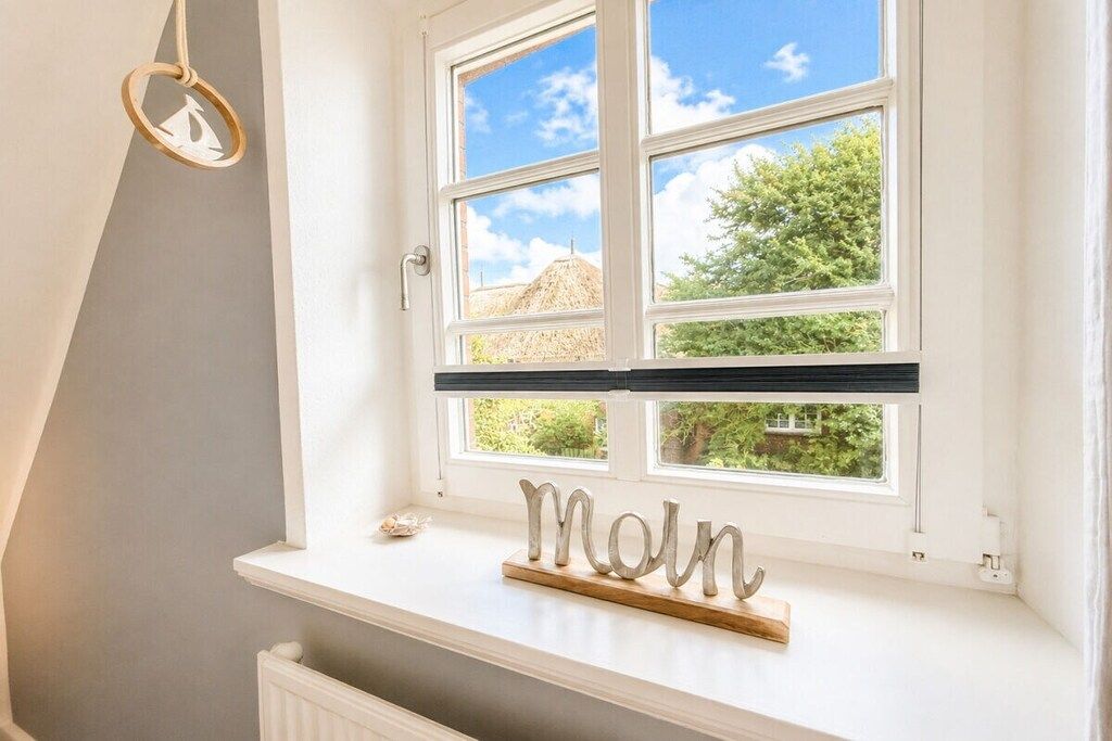 A window with a view of greenery and a building outside.