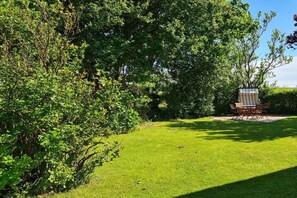 A well-maintained lawn with a covered seating area and a table. - Holiday apartment Ankerplatz Wrixum (Wrixum auf Föhr)