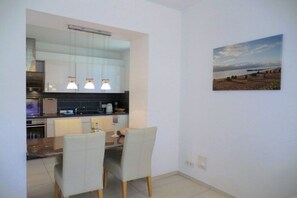 Eine moderne Küche mit Essbereich, großem Fenster und einem Bild an der Wand.