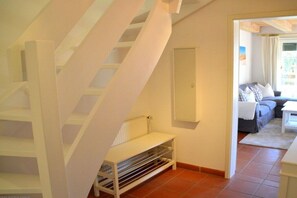 A staircase with a white handrail leading to a landing. A white shelf unit is placed on the landing. - Holiday home in Oldsum with swimming pool (Oldsum)