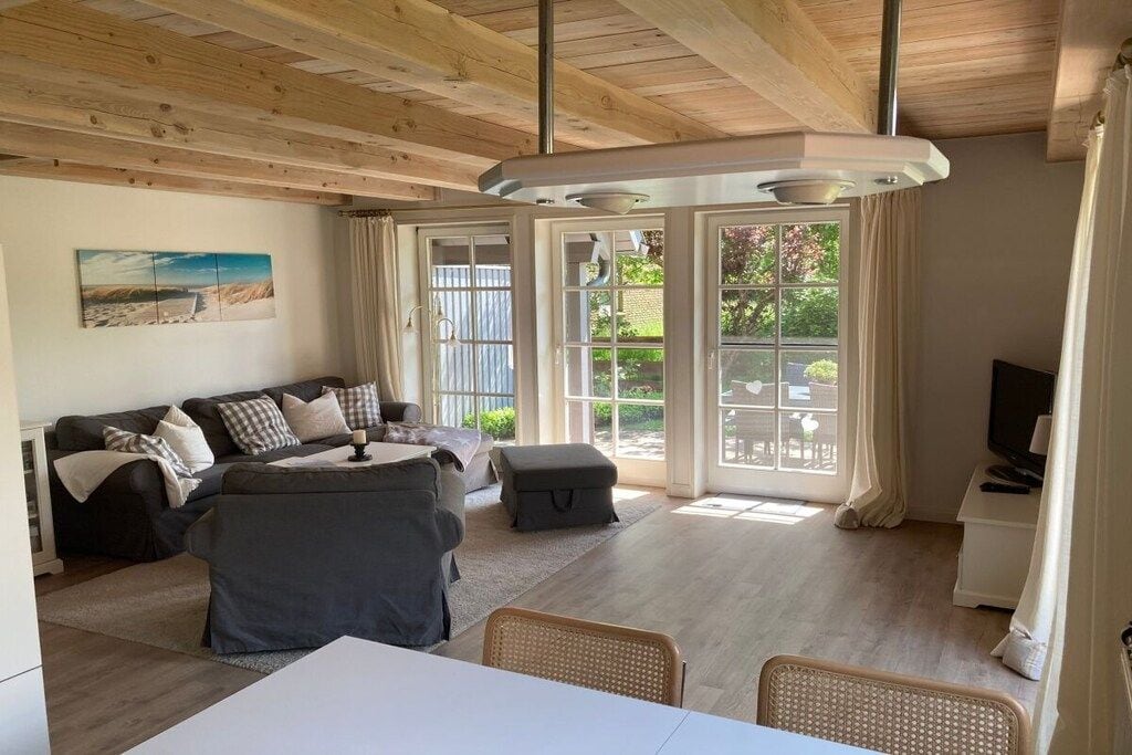 A cozy living room with a sofa, a dining table, and a TV.