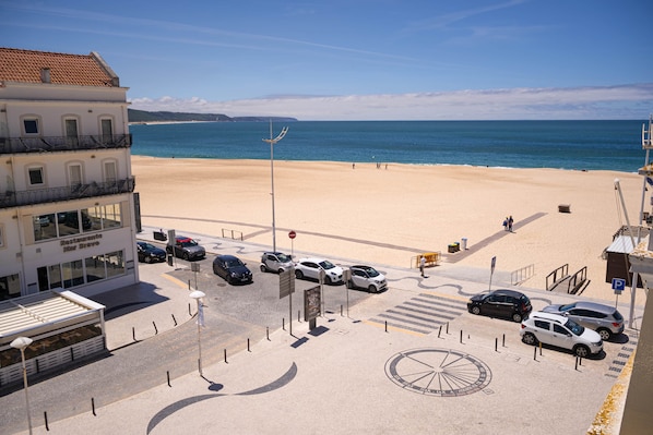 A beachside view with a building labeled 'Mar Bravo' and a parking area with cars.
