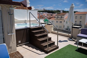 A rooftop terrace with a hot tub, wooden steps, and outdoor furniture. - Double Room with Balcony and Side Sea View (Nazaré)