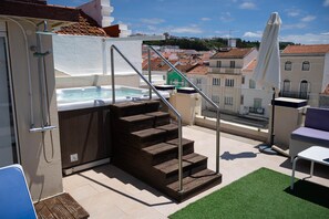 A rooftop terrace with a hot tub, wooden steps, and outdoor furniture. - Superior Double Suite with Balcony and Sea View (Nazaré)