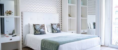 A modern bedroom with a large bed, built-in wardrobe, and a mirror.
