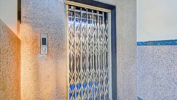 Une porte dotée d’une grille de sécurité en métal et d’un panneau de commande.