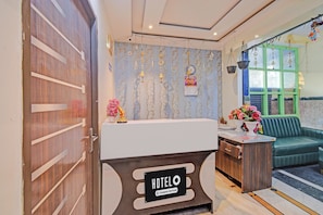 Una recepción de hotel con un letrero que dice 'HOTEL', un calendario y un florero.