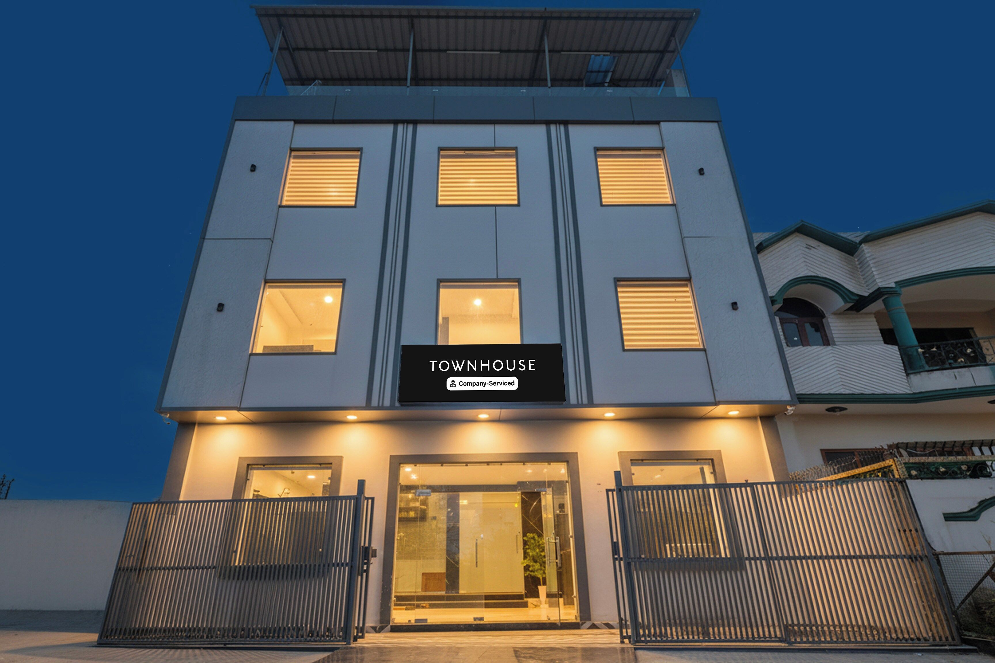 Un edificio moderno con un letrero que dice 'TOWNHOUSE Company Serviced'.
