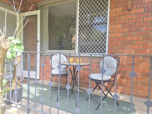 A balcony with two chairs, a small table, and a potted plant. - Chic Ground Floor 2BDR Apartment in Ashfield (Ashfield)