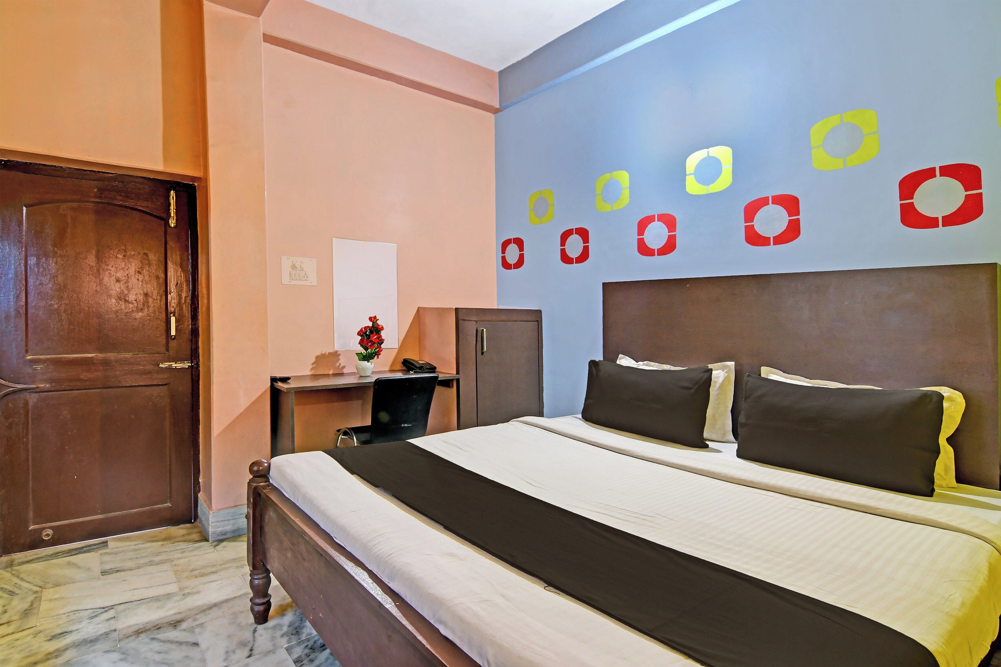 Una habitación de hotel con cama, escritorio, silla y armario.