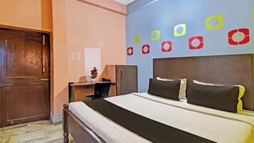Una habitación de hotel con cama, escritorio, silla y armario.