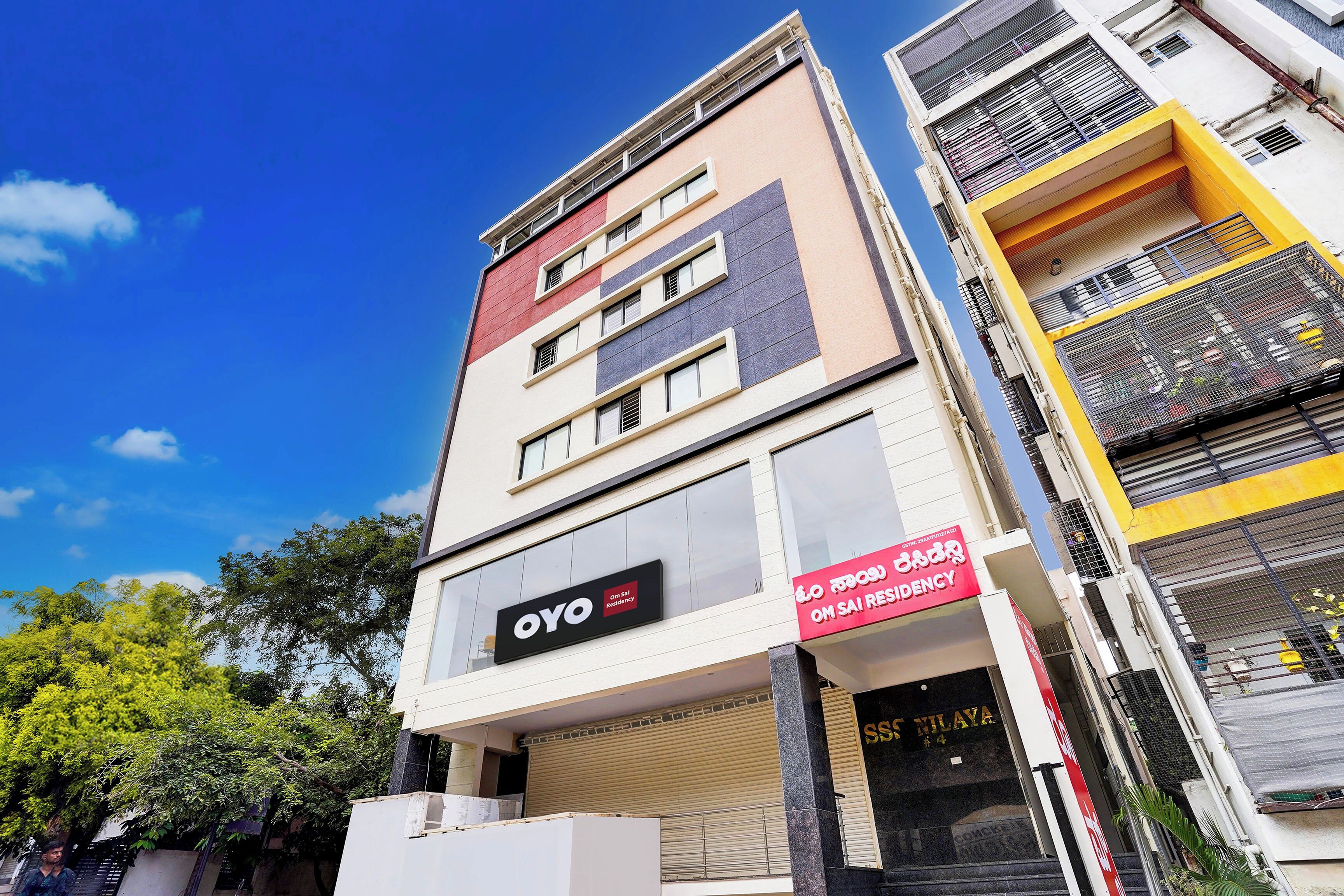 A multi-story building with a sign for 'OYO Residency' indicating a hotel or accommodation.