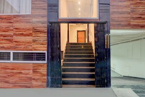 Escadaria que leva a um quarto com porta de madeira e janela.