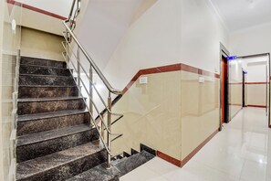 Una escalera con barandillas de metal que lleva a un rellano con una puerta marcada '13'.