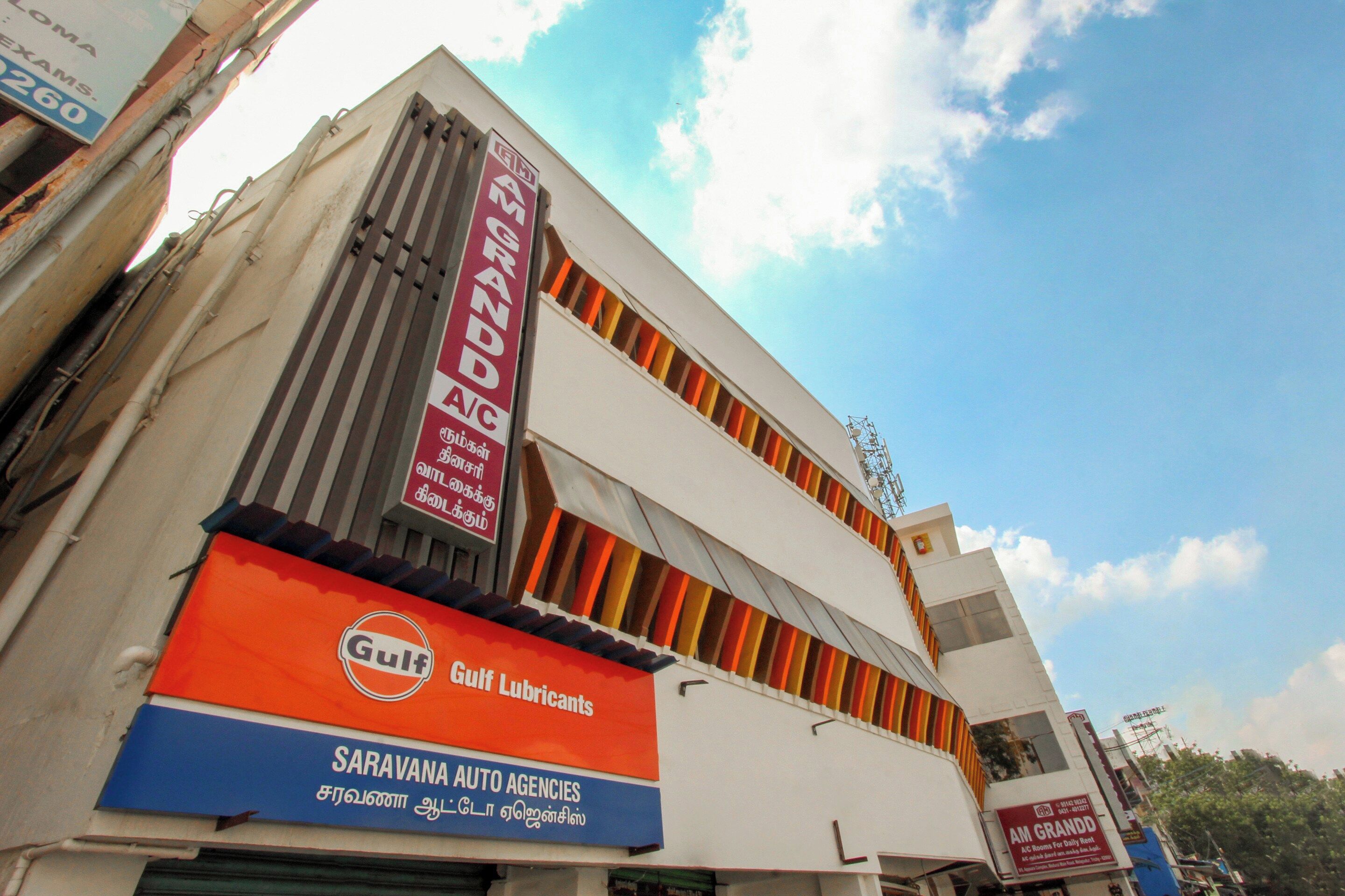 Un edificio de varios pisos con letreros de Gulf Lubricants y Saravana Auto Agencies.