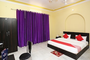 A hotel room with a bed, a wardrobe, a chair, and a curtain. - Hotel O Greenview Near Munshi Pulia (Lucknow)