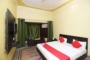 A hotel room with a bed, a TV, a desk, and a chair. - Hotel O Greenview Near Munshi Pulia (Lucknow)