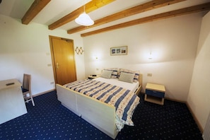 A bedroom with a bed, bedside tables, a desk, and a chair. - garni col da la vila (Penia di Canazei)