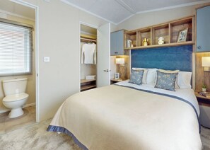 A bedroom with a bed, a bedside table, a nightstand, a wardrobe, and a window with blinds. - The Luxe with Hot Tub and enclosed garden (Hayle)
