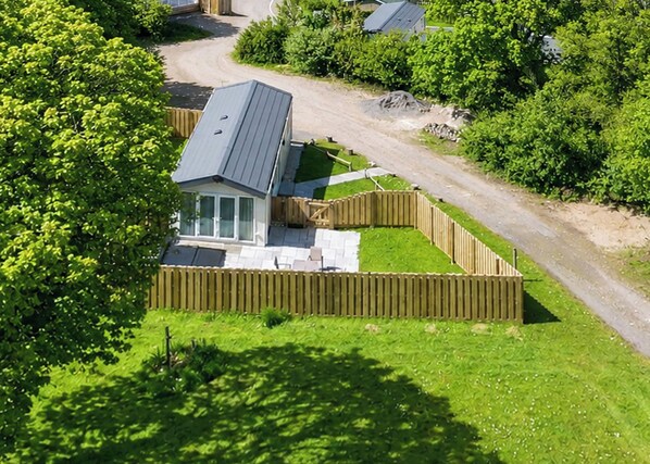 Ein Wohnhaus mit Zufahrtsweg und umzäunter Garten.