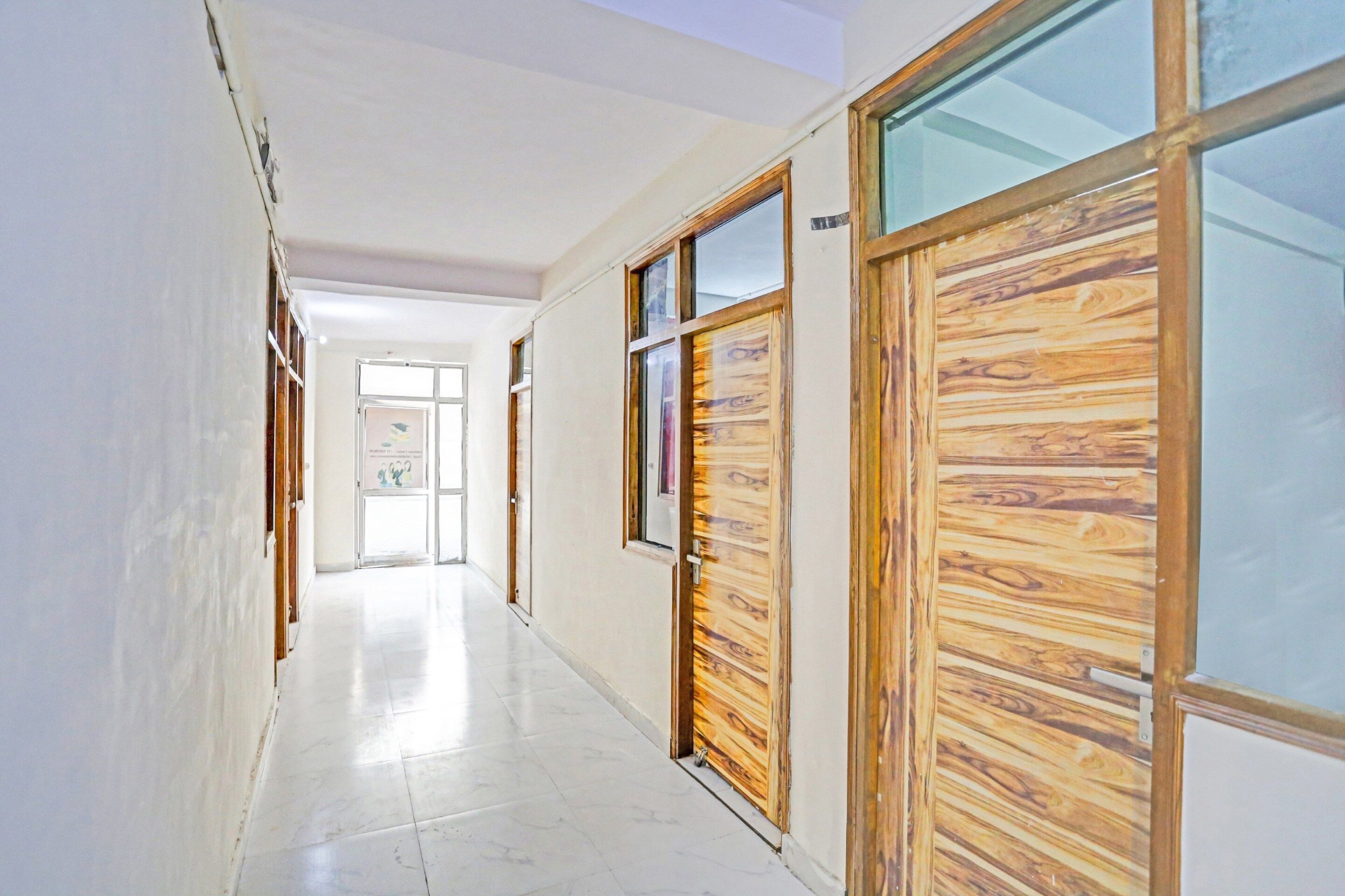 A hallway with wooden doors and a tiled floor.