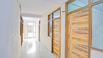 Un couloir avec des portes en bois et un sol carrelé.